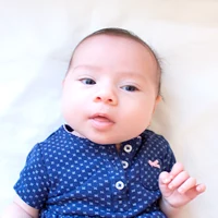 Baby on a white sheet looking at the camera